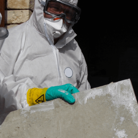A group of workers in PPE looks for asbestos in homes by performing an asbestos inspection for homeowners.