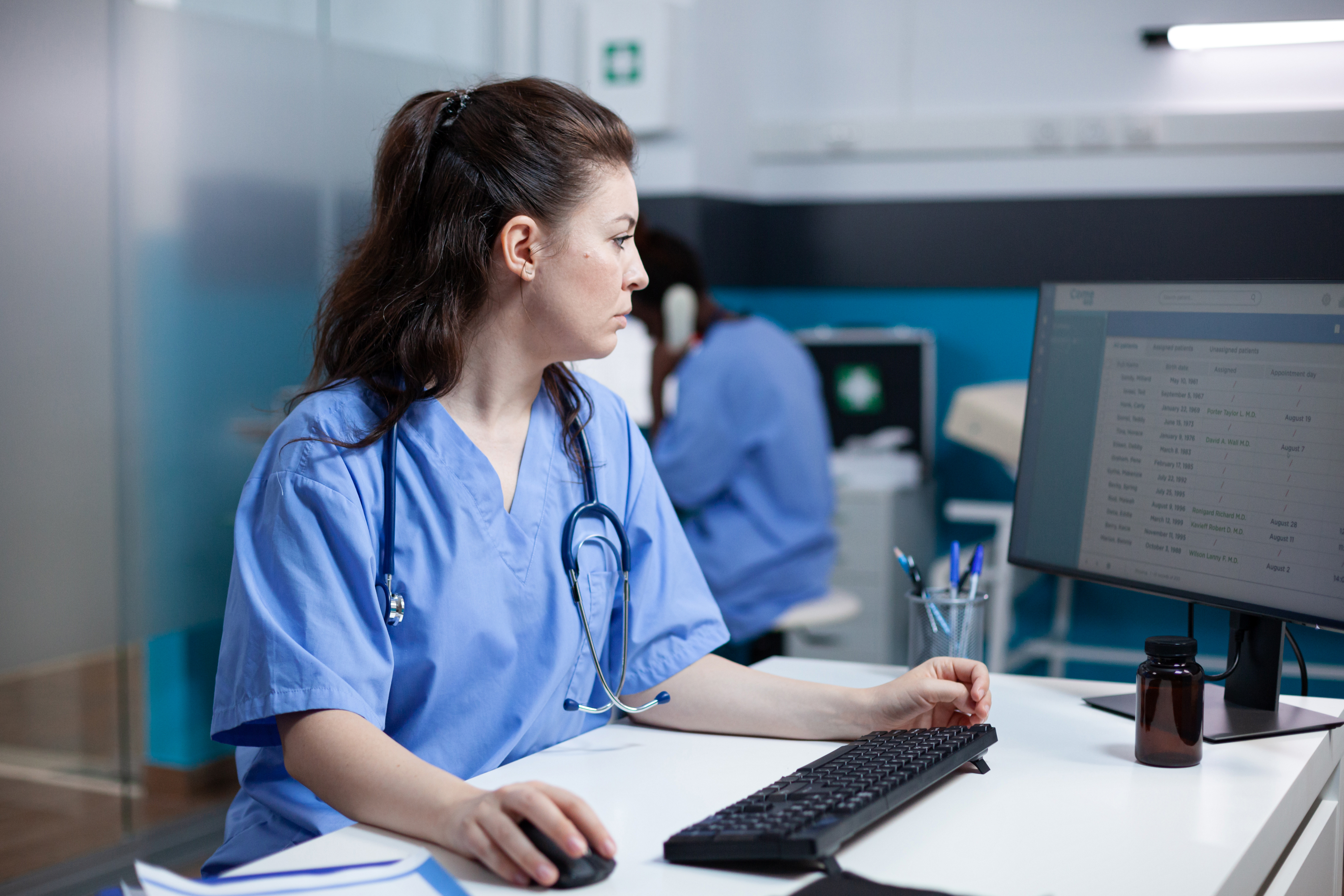 A medical professional checks a list of asbestos exposure patients on her computer.