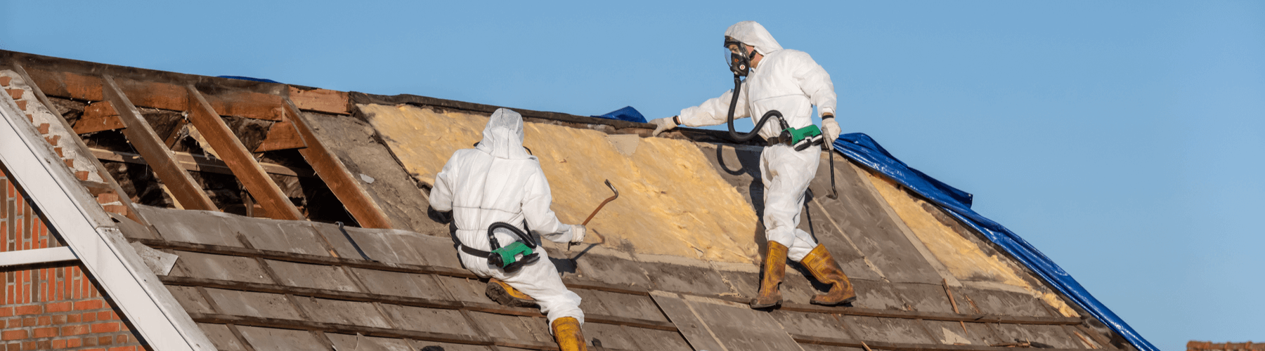 Professionals in protective suits removing asbestos