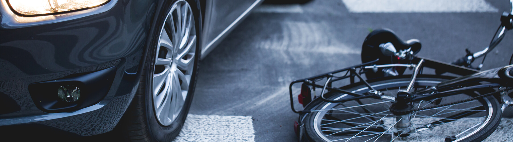 Car on the pedestrian path or crosswalk with the downed bicycle