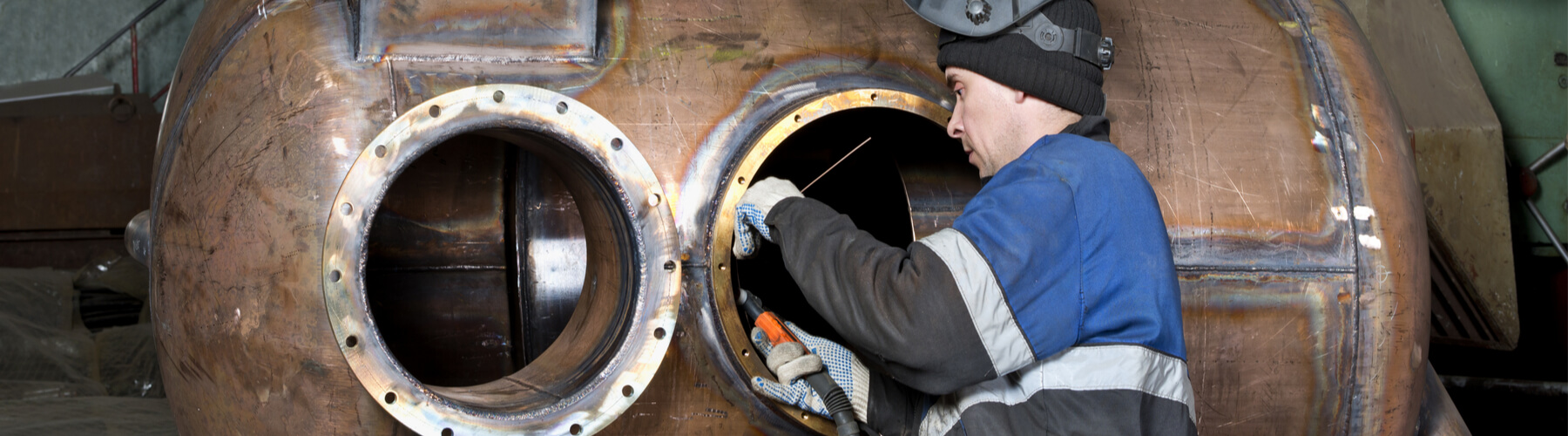 Male boiler maker working on a ship boiler