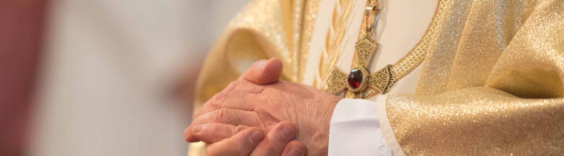 Catholic priest holding praying hands