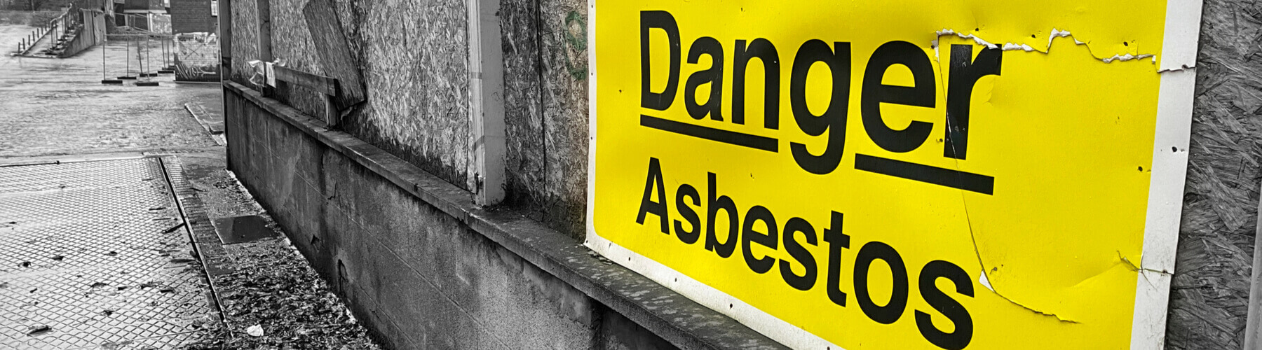 danger, asbestos sign on concrete wall