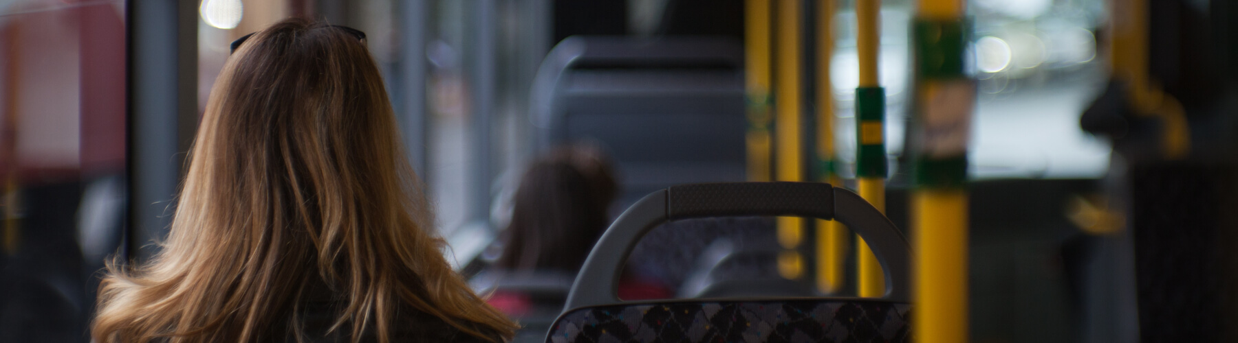 female sitting on a bus listening to headphones