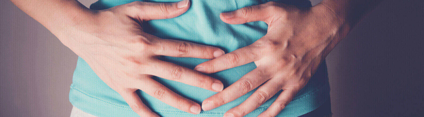 woman holding hands across abdomen