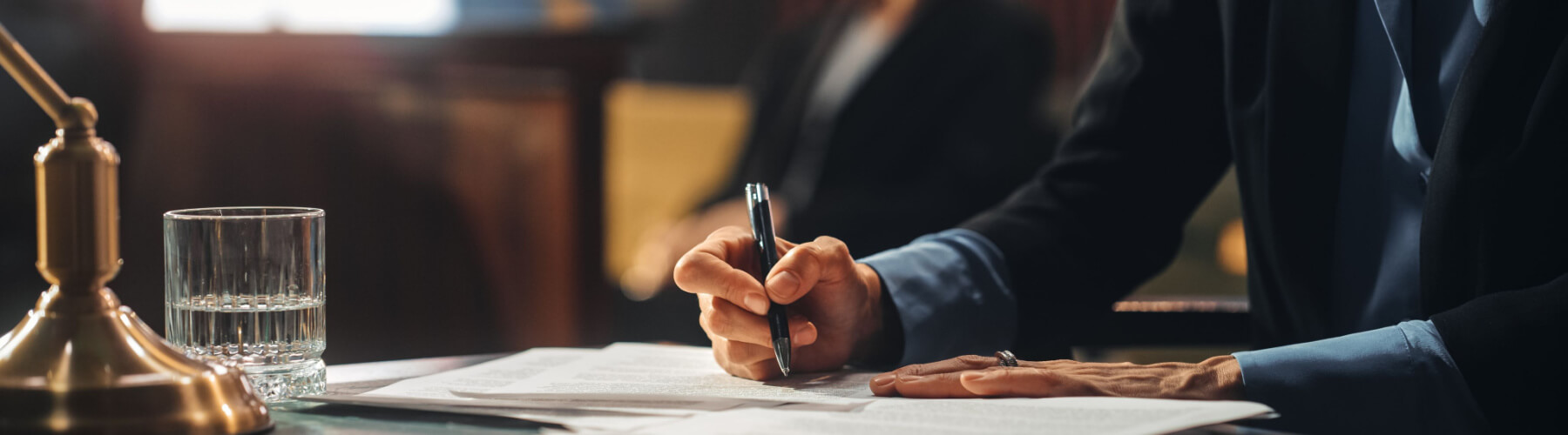 attorney in courtroom making notes at the table