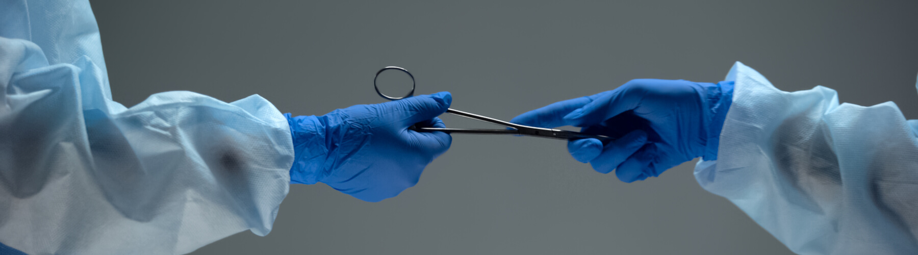 Surgeon giving scissors against dark background, illegal black-market surgery