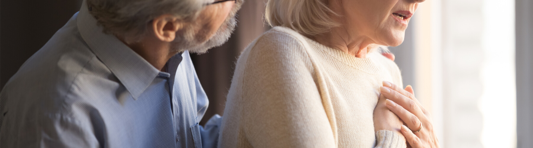 Close up focus on elderly wife hold hand on chest having chest pain