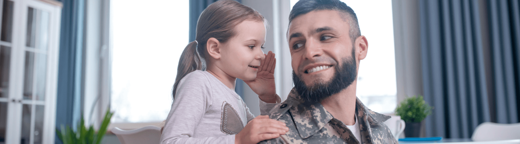 little girl whispering into military dad's ear