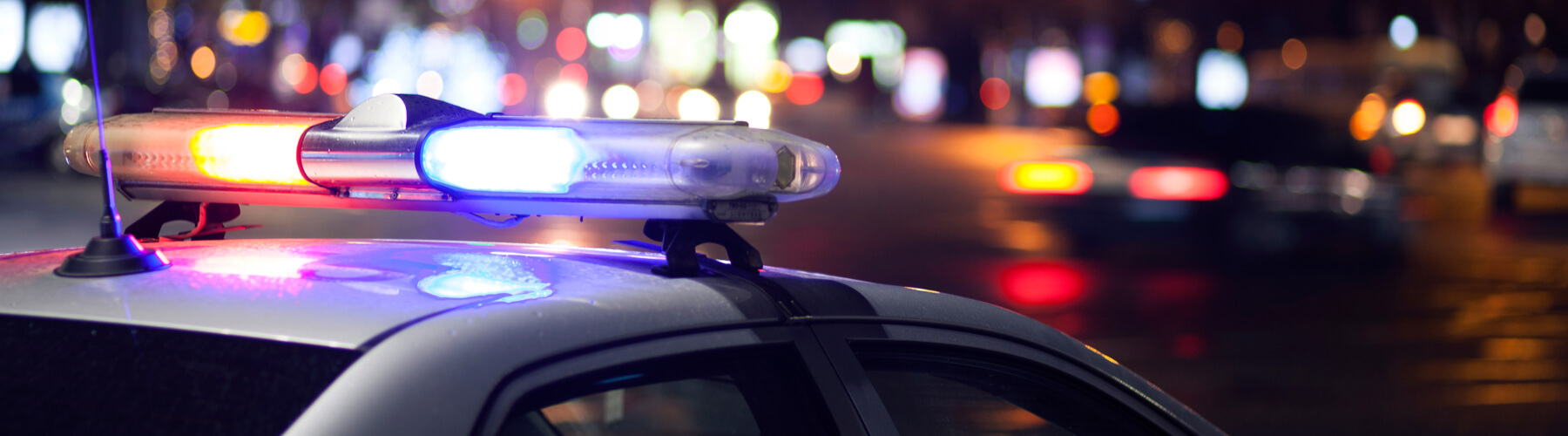 Danger on the road. Blue flasher on the police car at night.