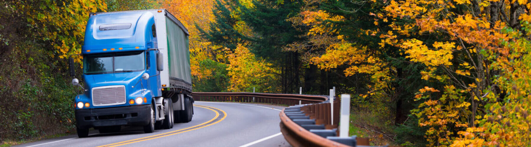 semi truck on curvy road in autumn