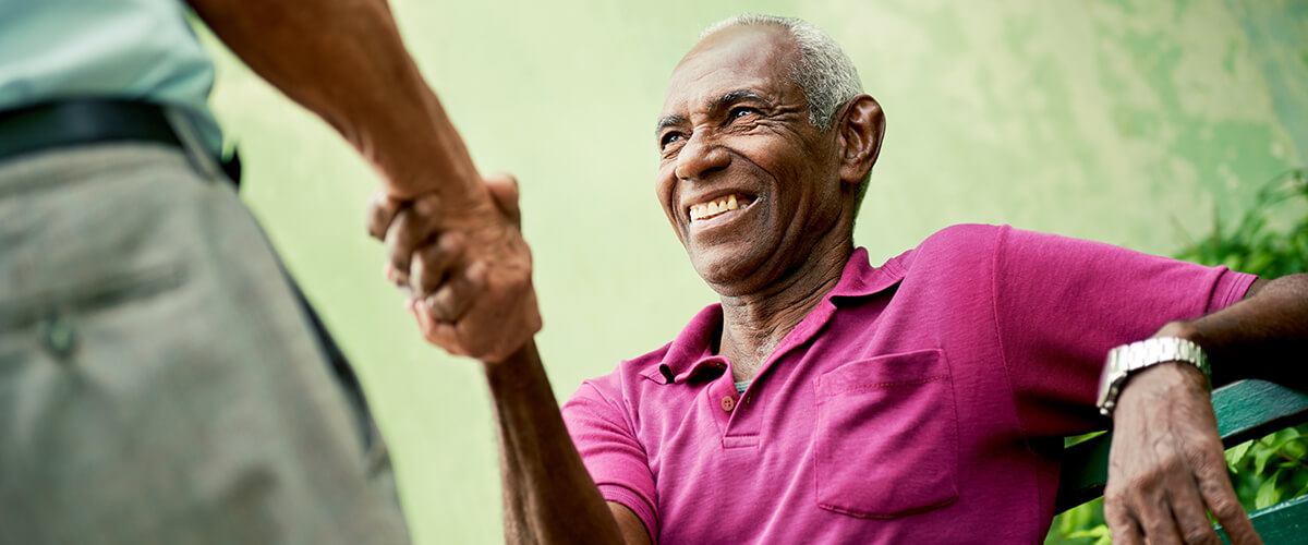 Smiling elderly man shaking hands with an attorney