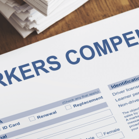 Individual filling out paper for workers compensation at desk