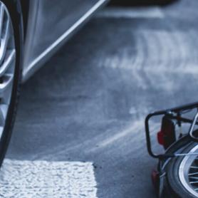 Car on the pedestrian path or crosswalk with the downed bicycle