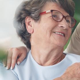 helpful caregiver comforting smiling senior woman, comforting senior patient