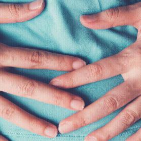 woman holding hands across abdomen