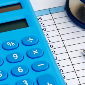 calculator and stethoscope on top of medical bill