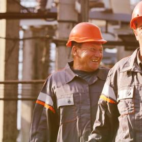 Three male workers walking away from a power plant, end of shit concept. Asbestos exposure concept for power plant workers or industrial facilities