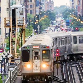 Train on elevated tracks within buildings at the Loop, Glass and Steel bridge between buildings - Chicago City Center - Chicago, Illinois, USA W