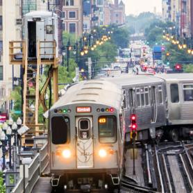 Train on elevated tracks within buildings at the Loop, Glass and Steel bridge between buildings - Chicago City Center - Chicago, Illinois, USA  W