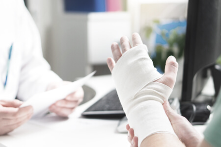 Person with an injured hand consulting a doctor