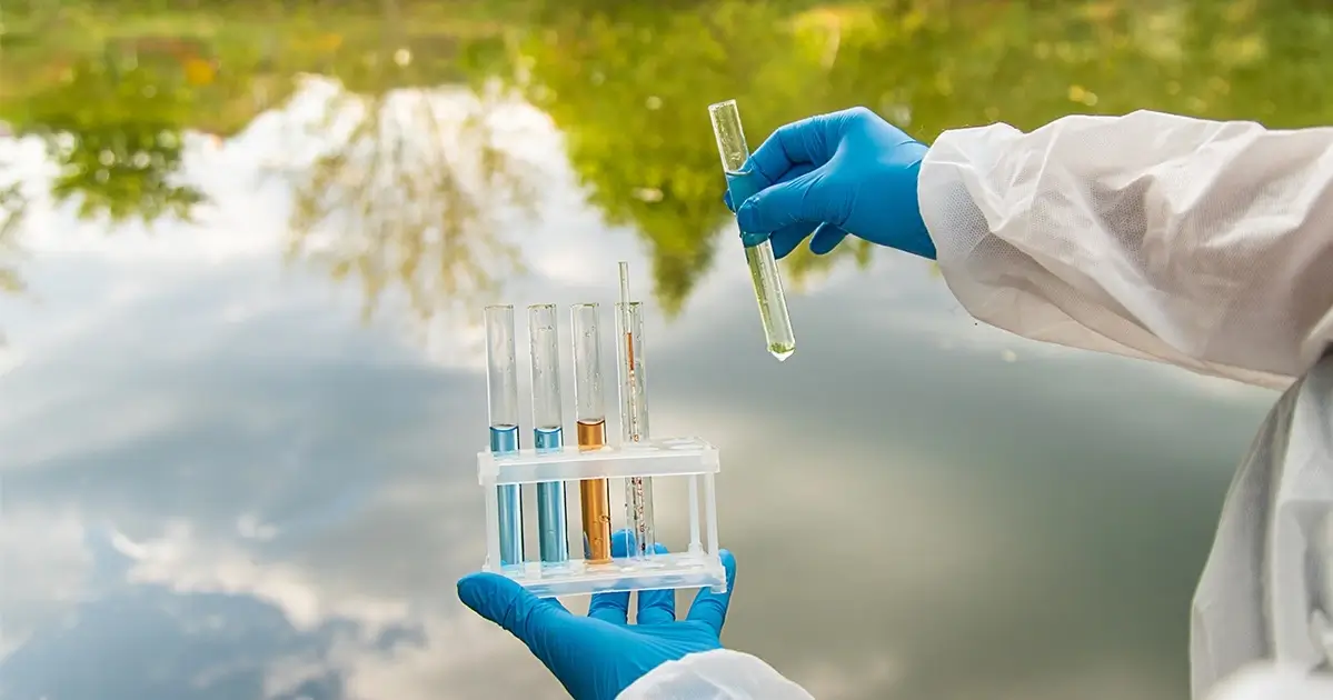 Scientist conducting water quality analysis using test tubes
