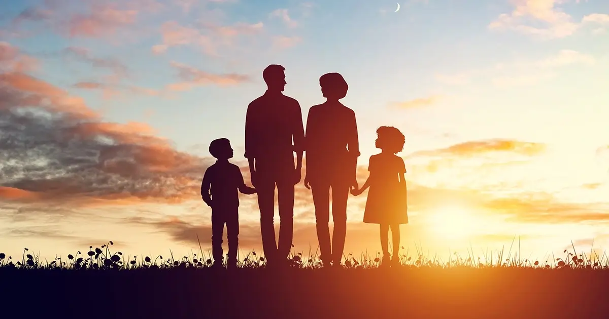 Silhouette of a family holding hands at sunset, symbolizing loss and grief